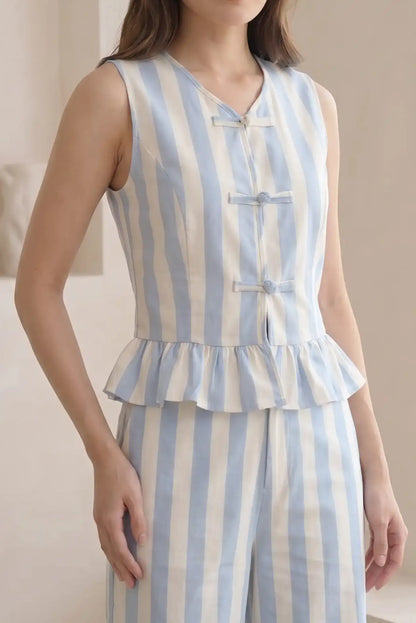 Chaleco de mujer sin mangas con rayas azul y blanco, detalle de volantes y botones decorativos.
