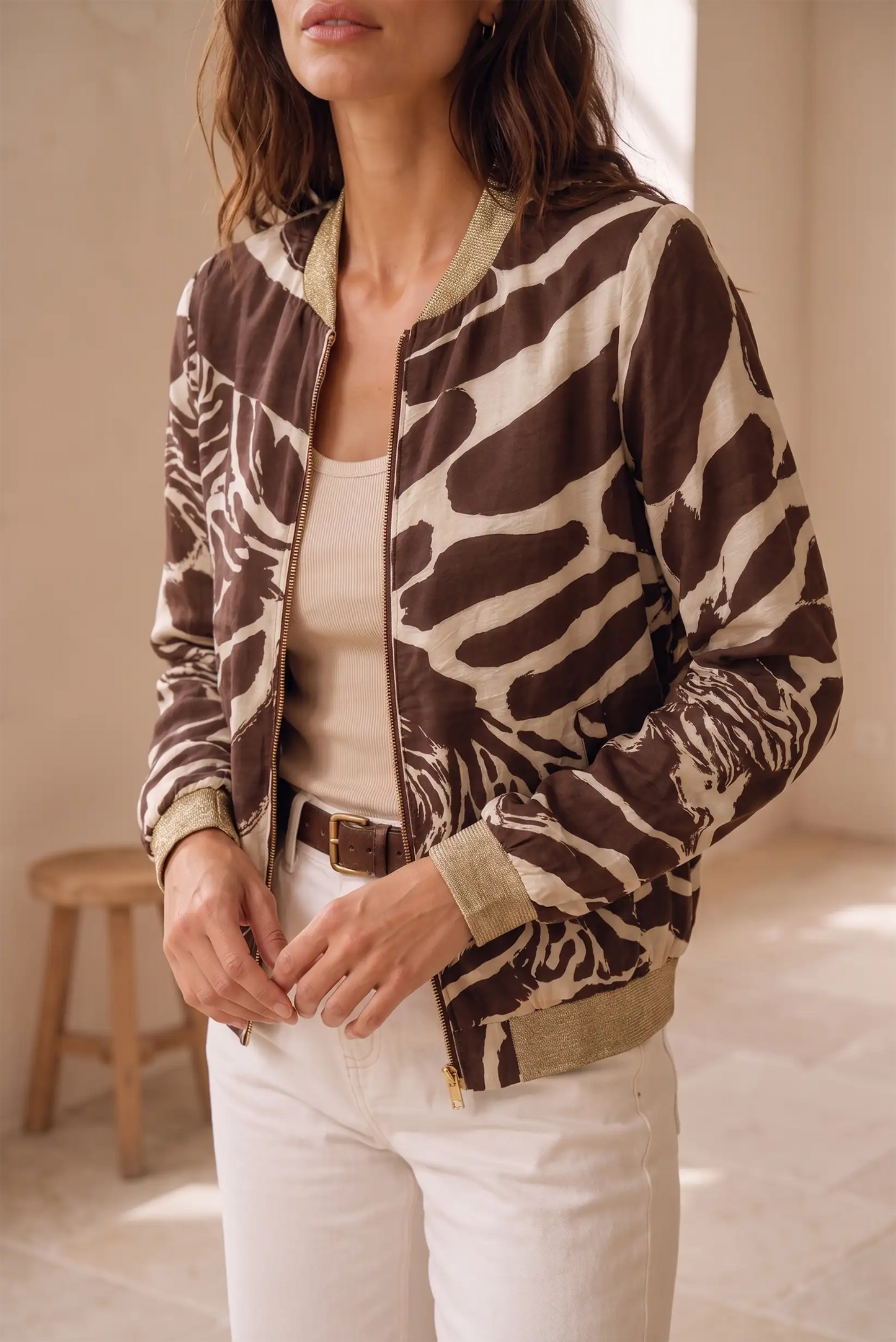 Mujer vistiendo chaqueta bomber con estampado animal en tonos marrón y beige