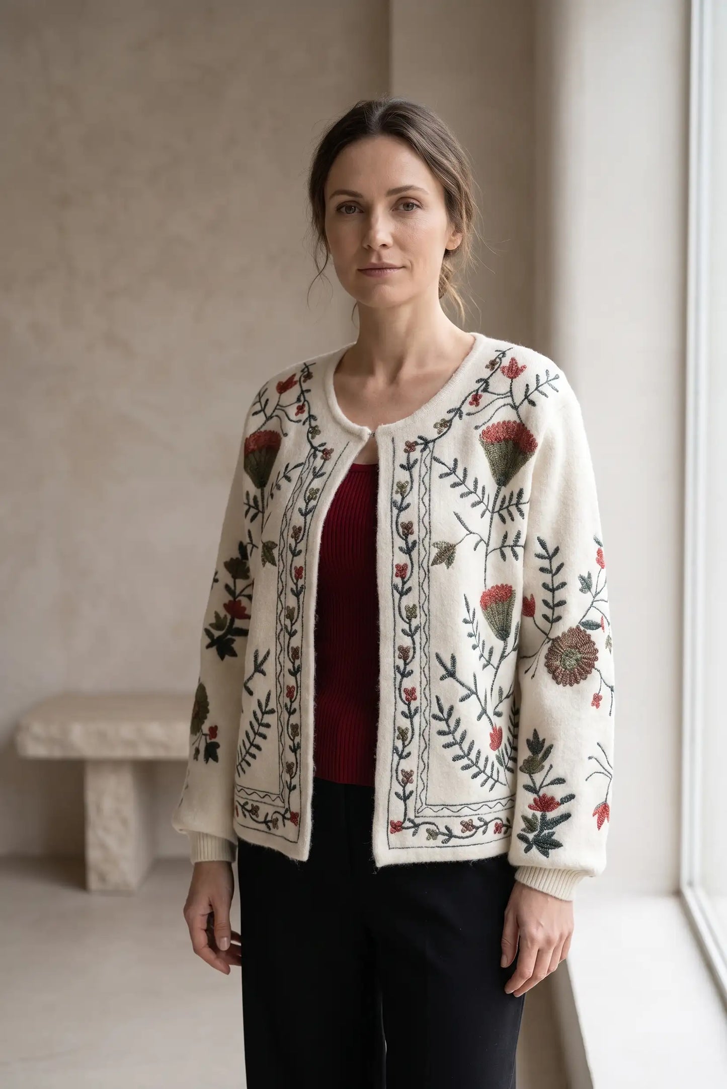 Mujer vistiendo cárdigan blanco con bordados florales coloridos y camiseta roja.