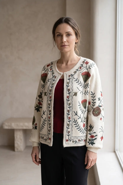 Mujer vistiendo cárdigan blanco con bordados florales coloridos y camiseta roja.