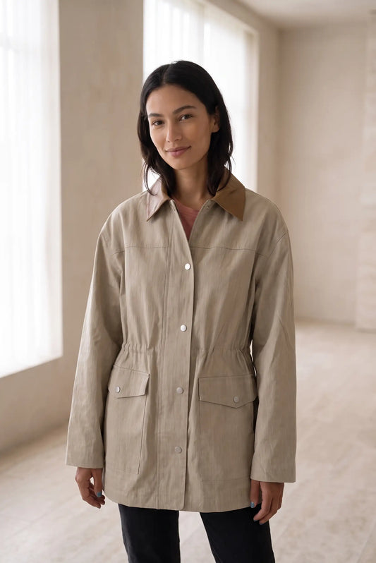 Mujer vistiendo chaqueta beige con cuello marrón y cintura ajustada
