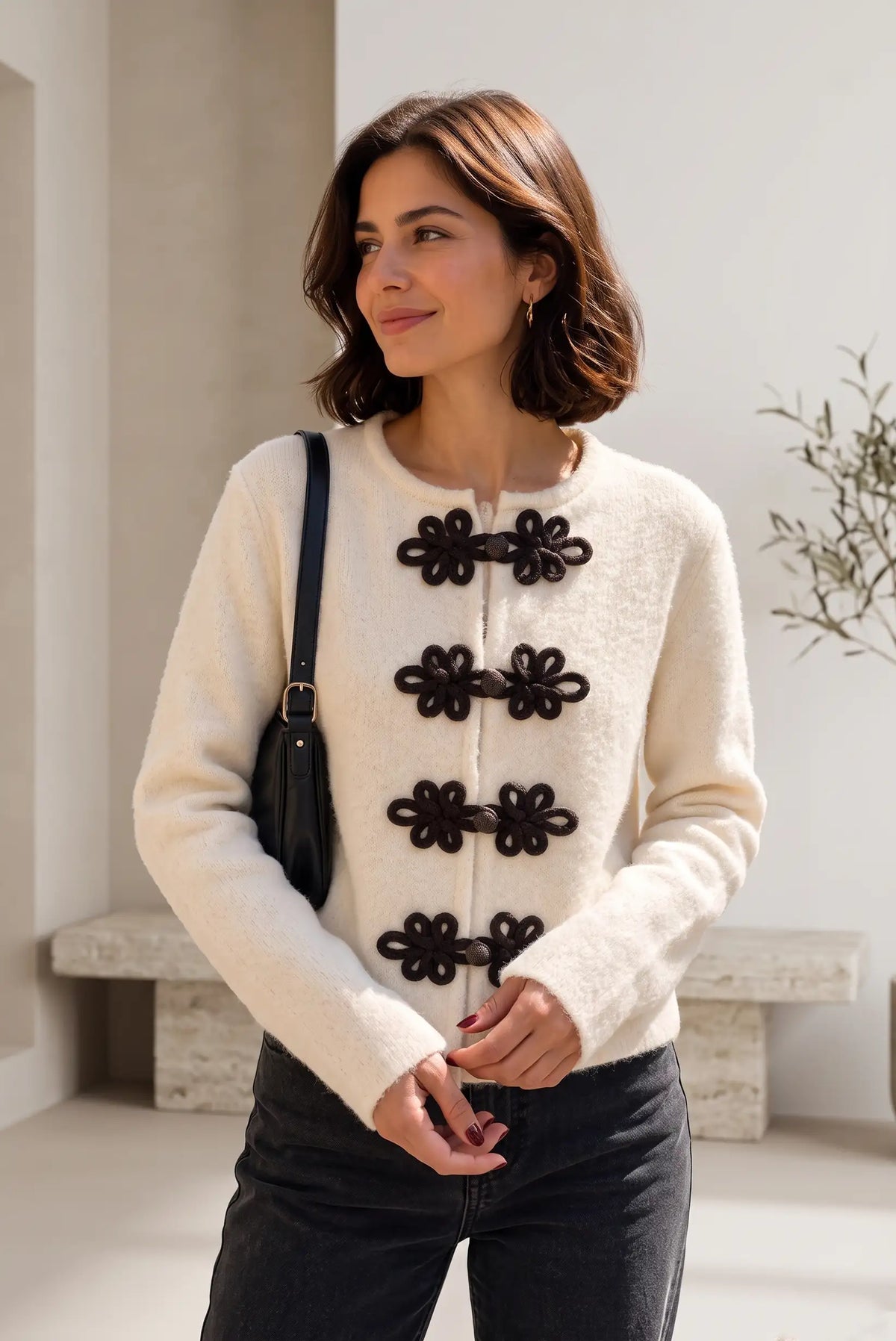 Mujer vistiendo chaqueta beige estilo Napoleón de CHICA del Sur con cierres decorativos negros.