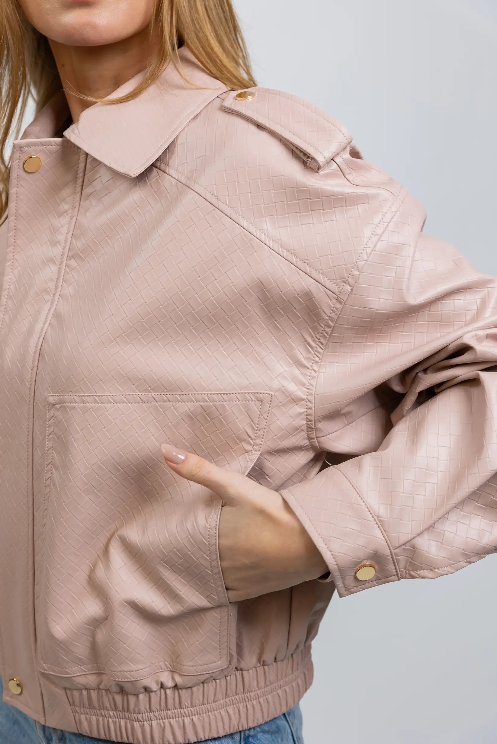 Chaqueta de mujer rosa claro en polipiel con textura y botones dorados, estilo casual.