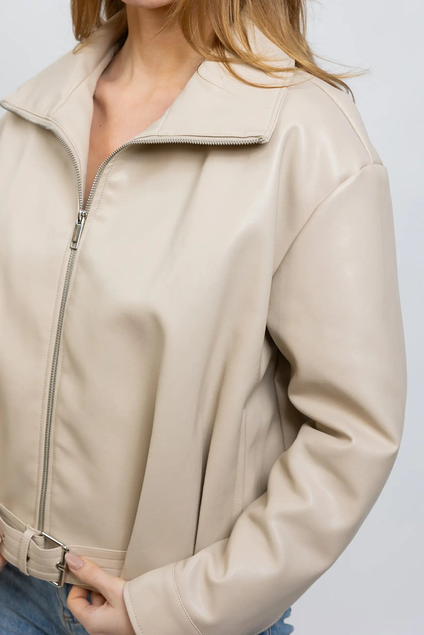 Chaqueta corta beige de polipiel para mujer, con cremallera y cinturón. Moda entretiempo.
