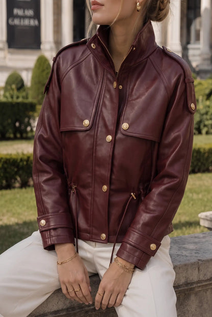 Chaqueta de cuero roja con botones dorados y detalles militares, ideal para moda femenina