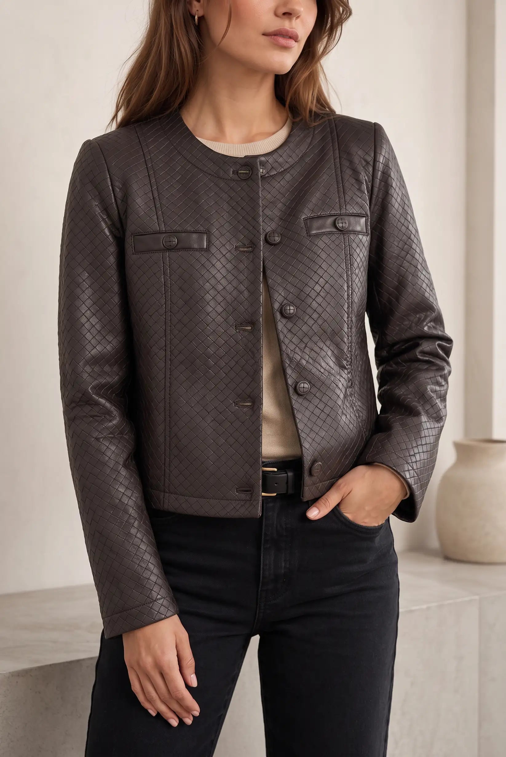 Chaqueta de cuero marrón con textura trenzada, botones y bolsillos, ideal para moda femenina elegante y casual.