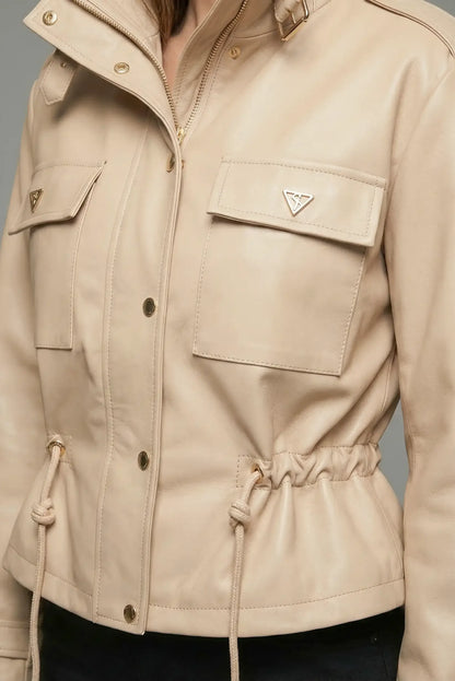 Chaqueta de mujer beige de polipiel, con bolsillos frontales y cierre de cremallera y botones.