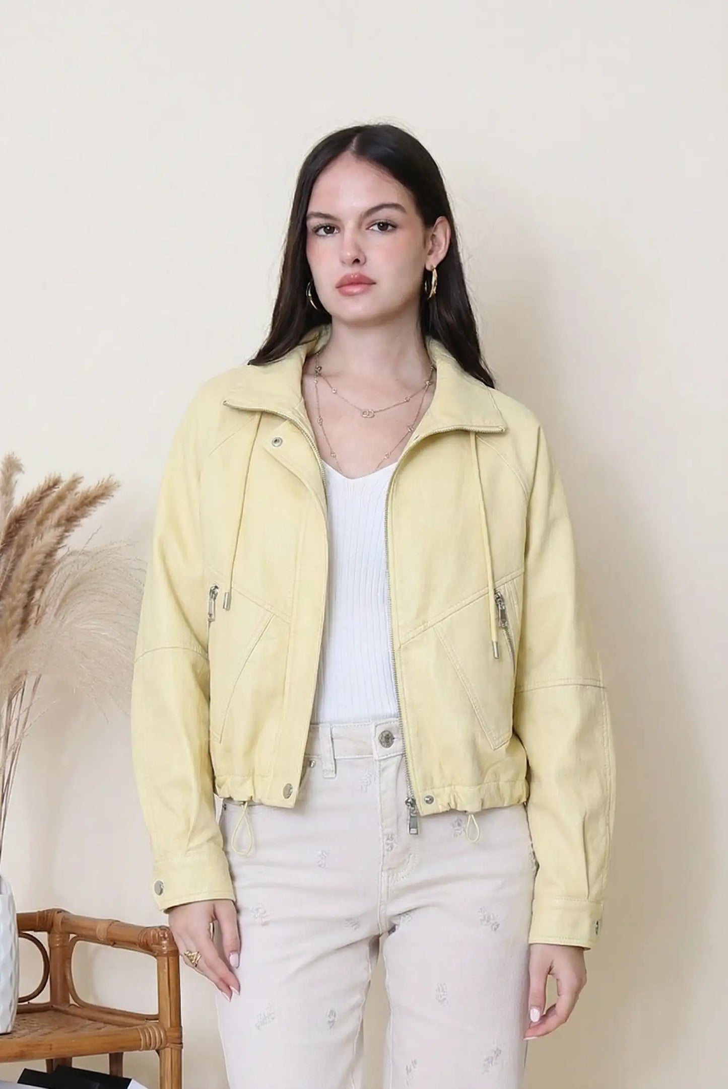 Mujer con chaqueta amarilla de polipiel estilo casual, sobre fondo neutro, moda primavera
