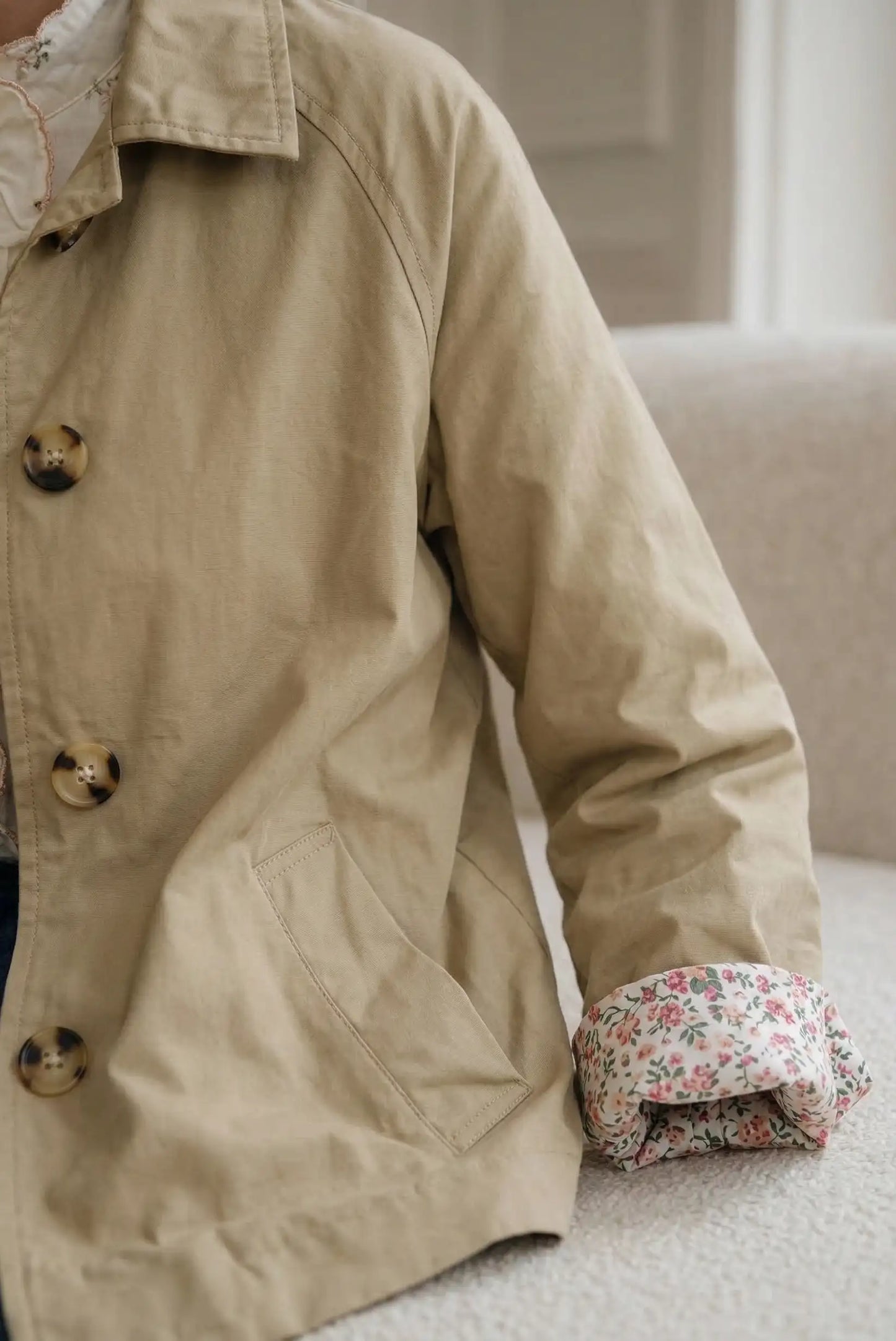 Chaqueta beige de mujer con botones grandes y detalle de puños con forro floral