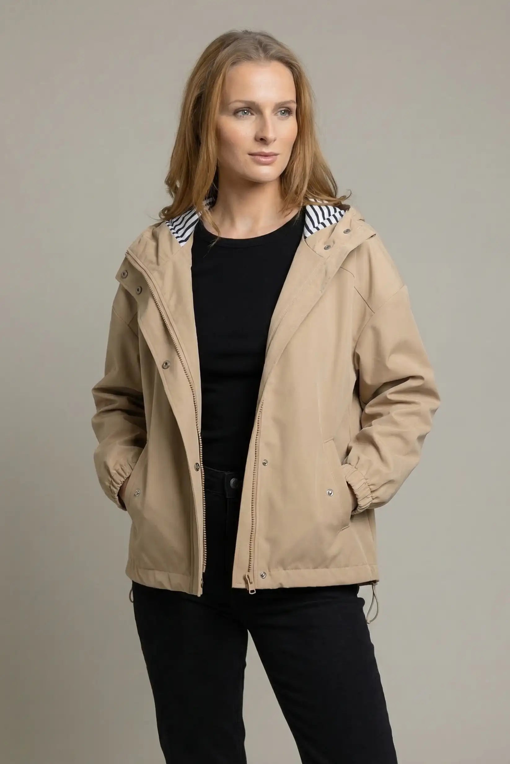 Chubasquero corto beige de mujer con capucha y forro de rayas, look casual moderno