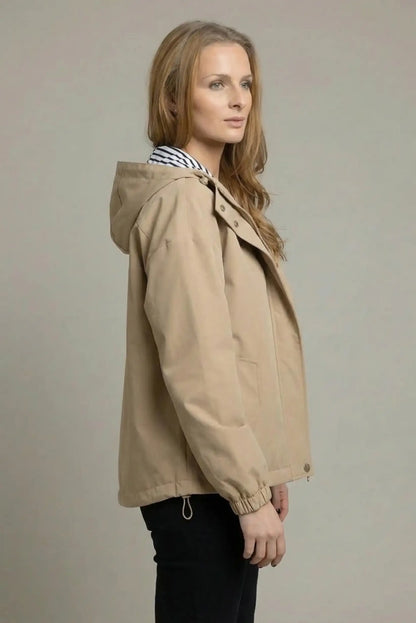 Mujer con chubasquero corto beige, capucha y forro de rayas, moda casual femenina