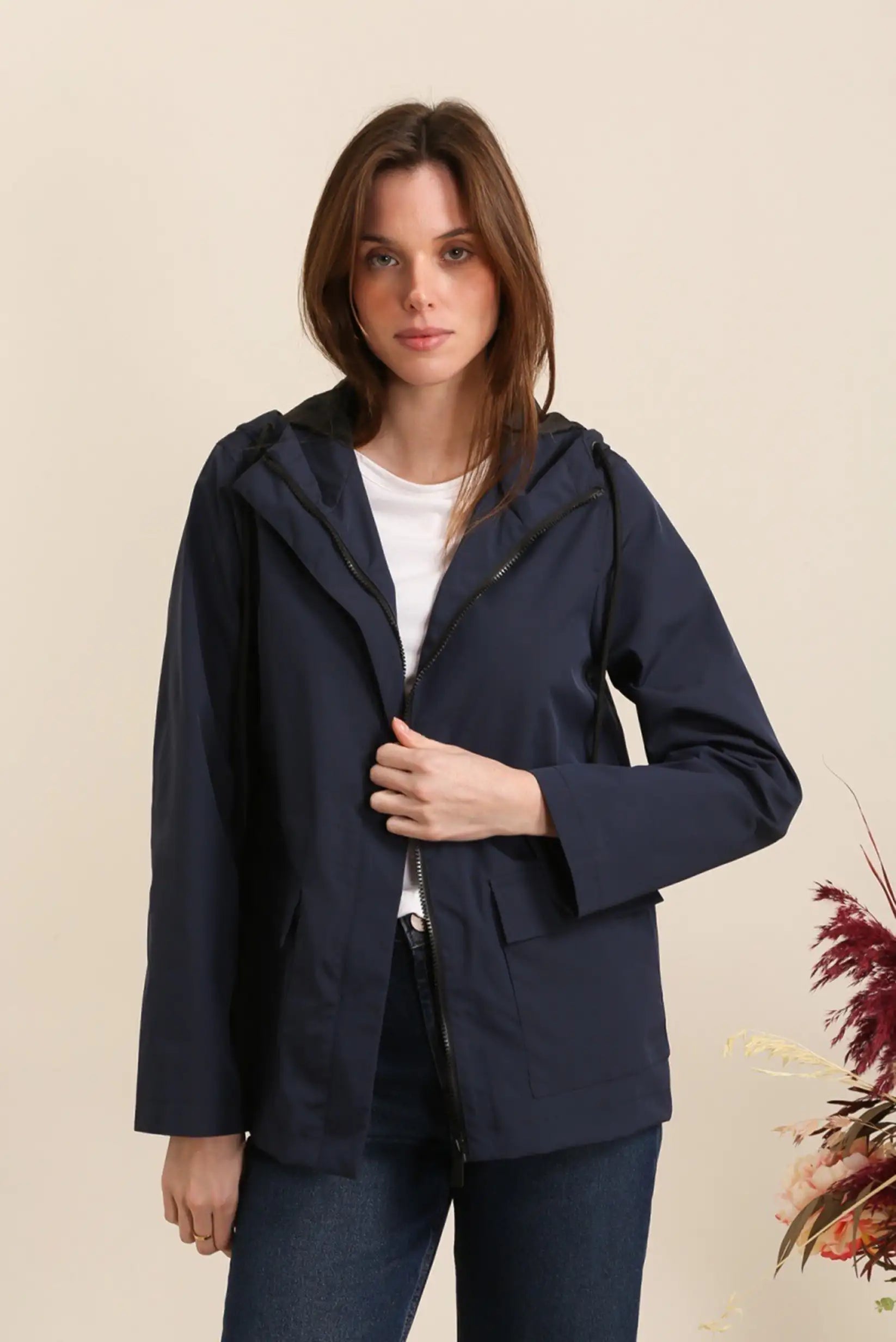 Mujer con chubasquero corto azul oscuro, look casual CHICA del Sur, fondo neutro.