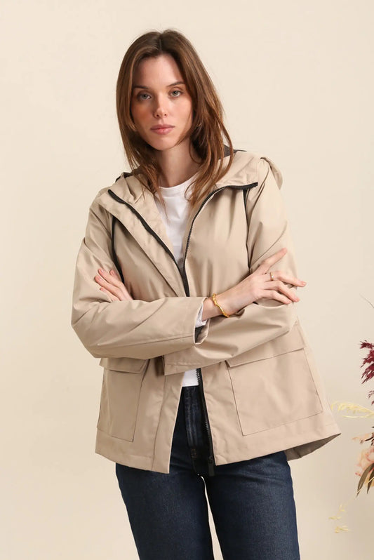Mujer con parka impermeable beige, moda femenina casual CHICA del Sur, fondo neutro.