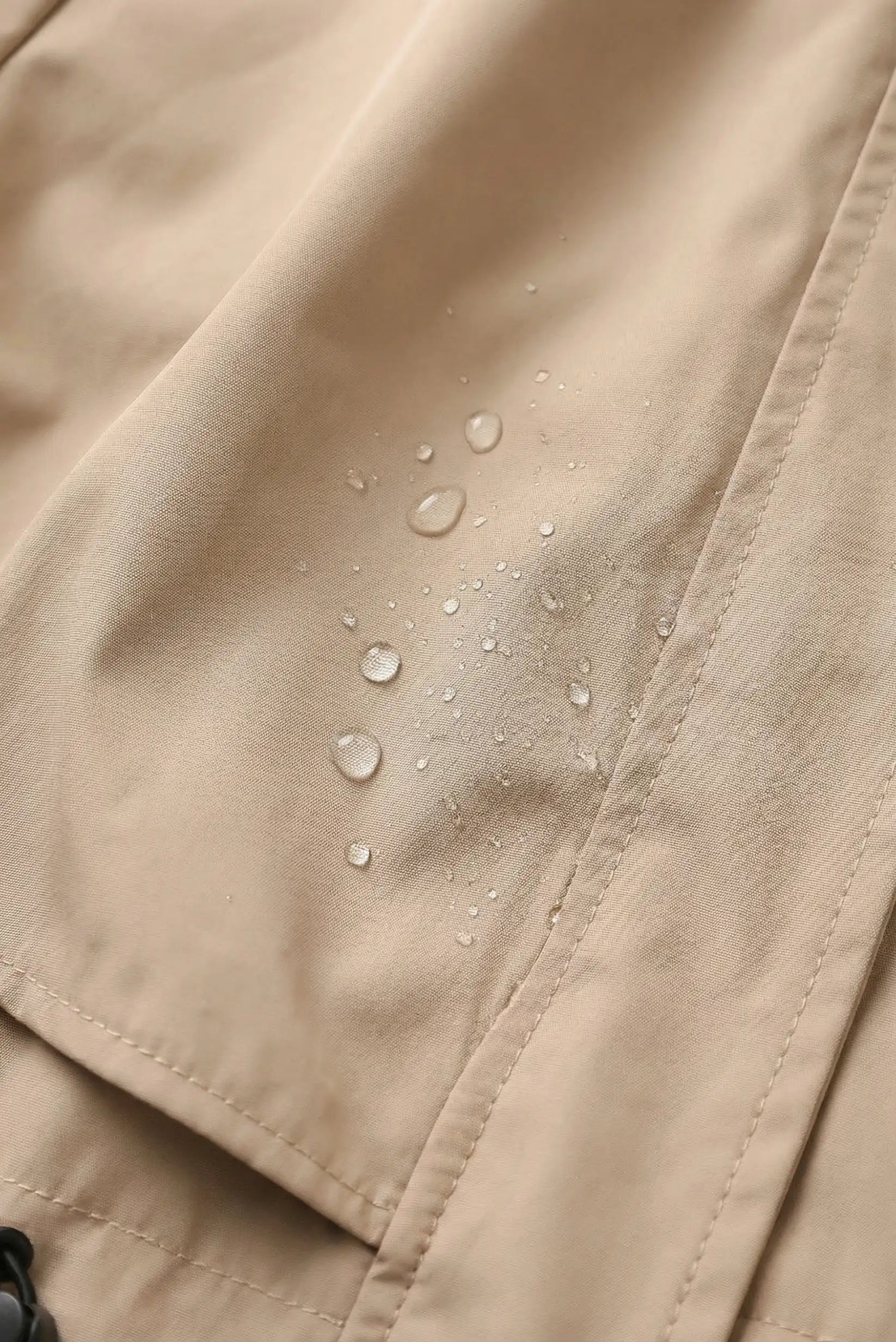 Detalle de chubasquero beige mujer repelente al agua con gotas, moda CHICA del Sur