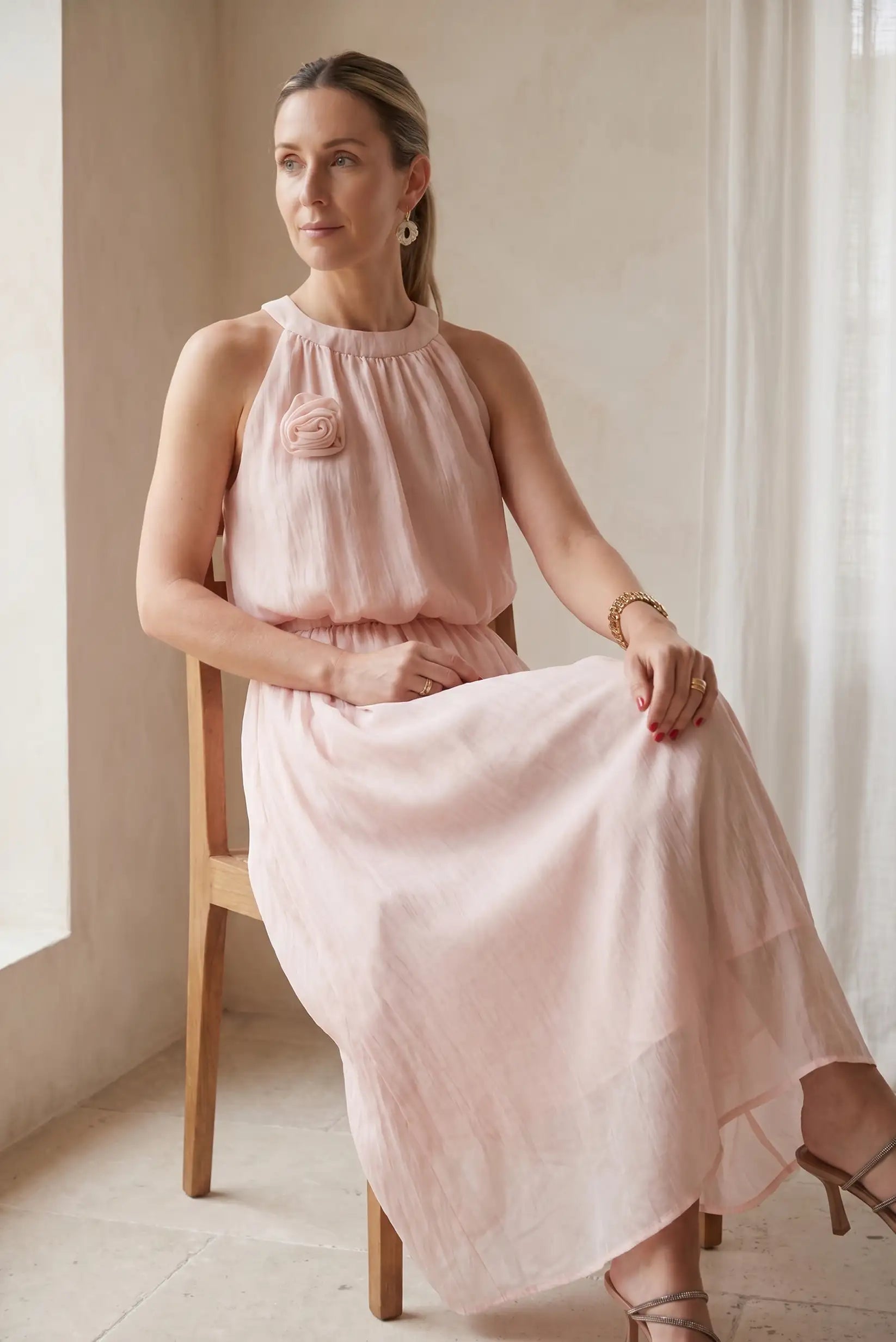 Mujer con conjunto rosa empolvado de falda larga y top fluido, look elegante de primavera