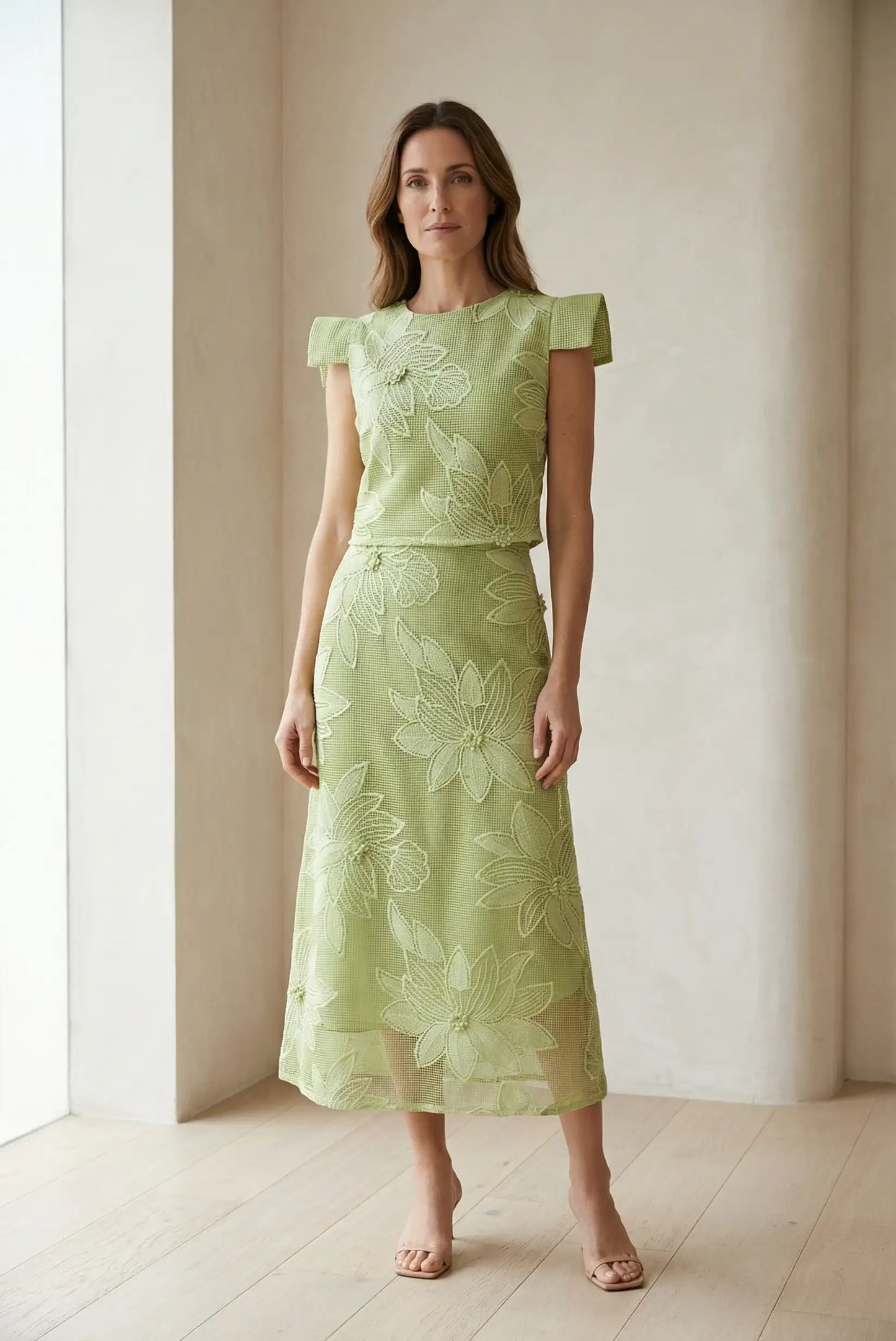 Mujer con conjunto de top y falda verde manzana, flores en relieve, estilo primavera elegante.