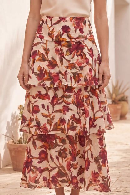 Falda midi floral con capas, estampado de flores rojas y marrones, ideal para looks femeninos y elegantes.