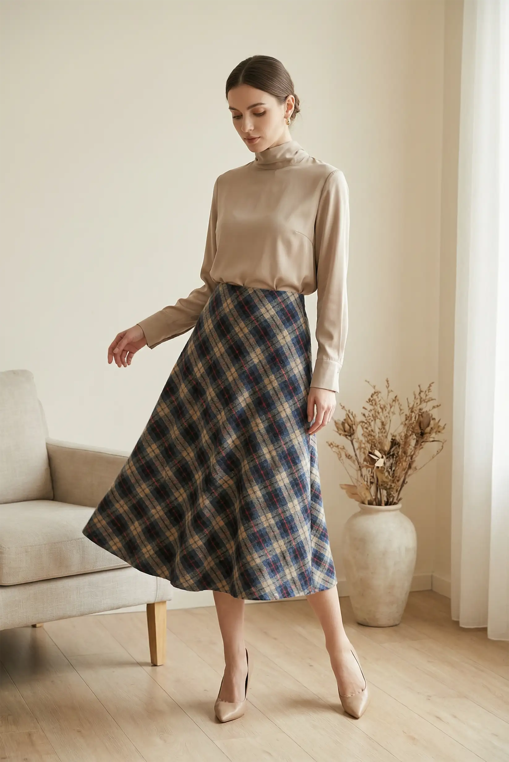 Mujer con falda larga de cuadros azul y rojo, blusa beige y zapatos nude en sala moderna