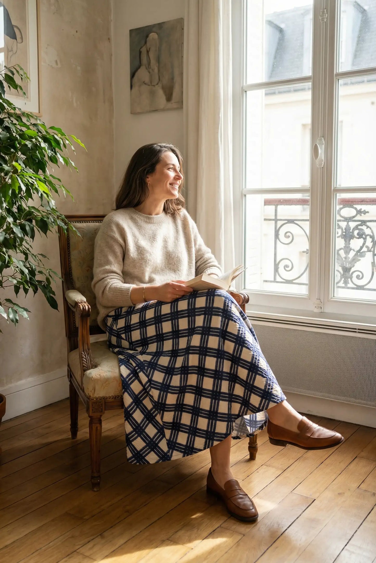 Mujer sentada con falda larga de rombos azules y suéter beige, look casual CHICA del Sur