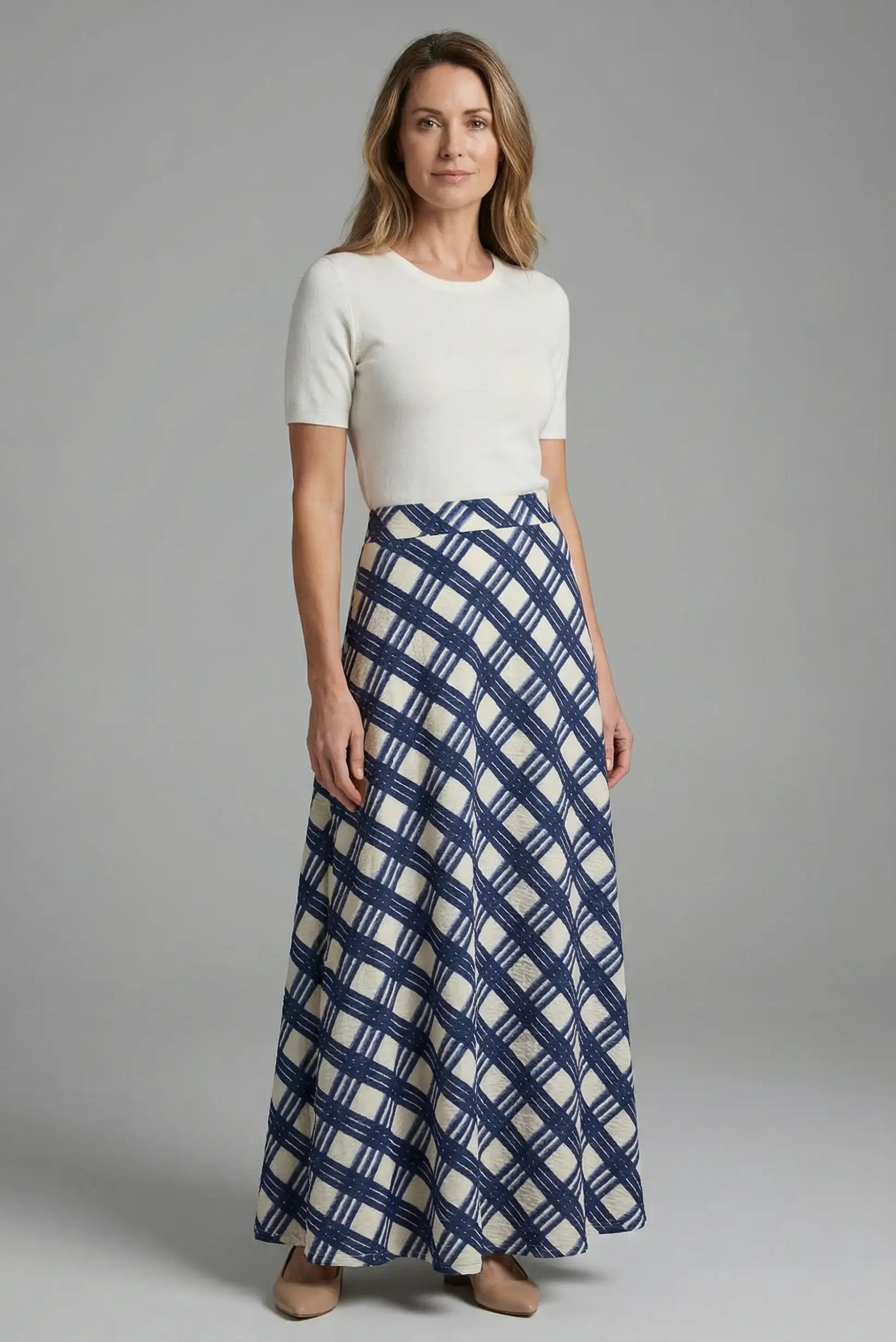 Mujer con falda larga de rombos azules y blusa blanca, moda femenina CHICA del Sur