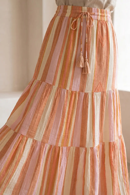 Falda larga de rayas en tonos naranjas y beige, con cinturón ajustable y textura ligera.