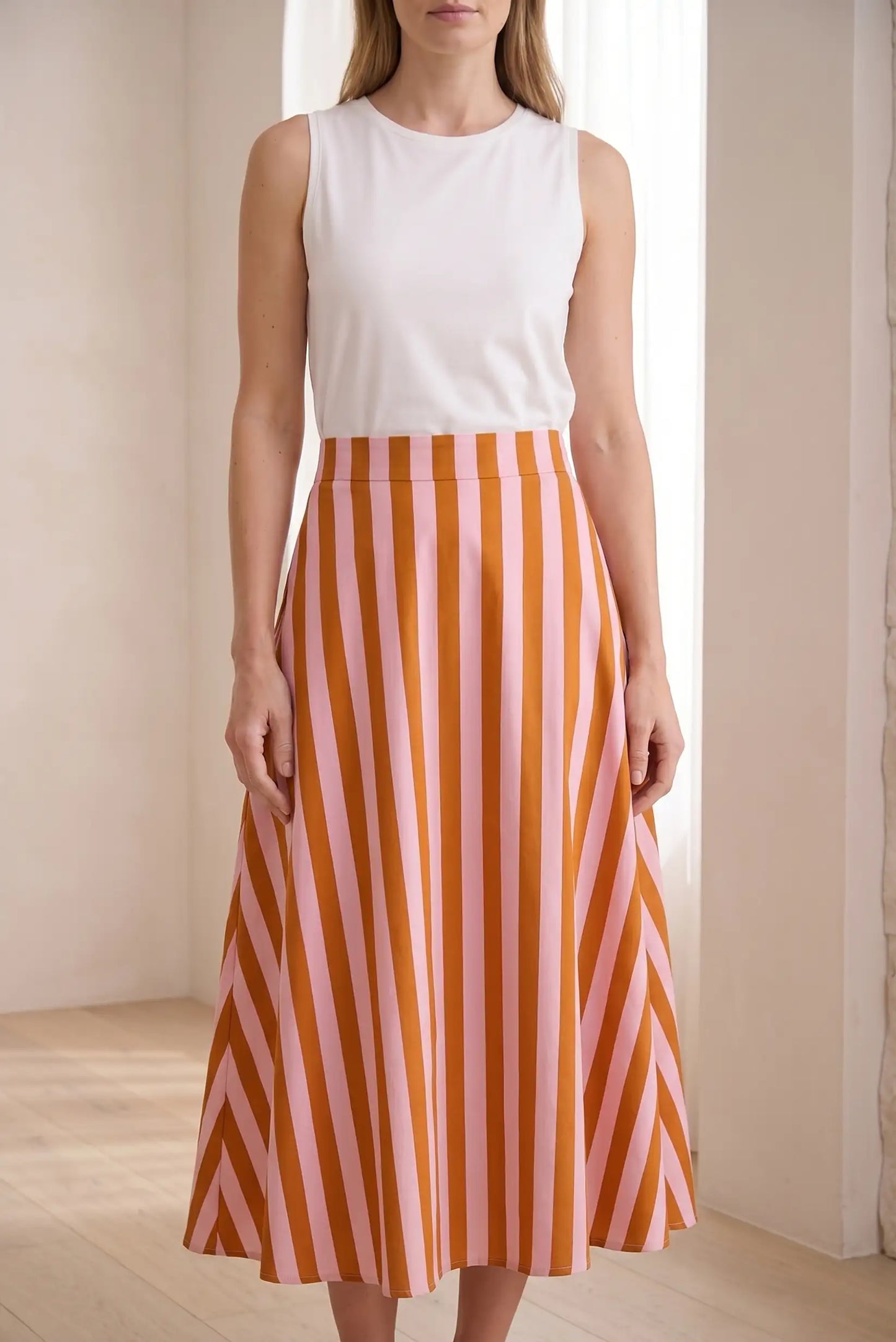 Falda larga de rayas rosas y naranjas, estilo casual de primavera, mujer de pie.