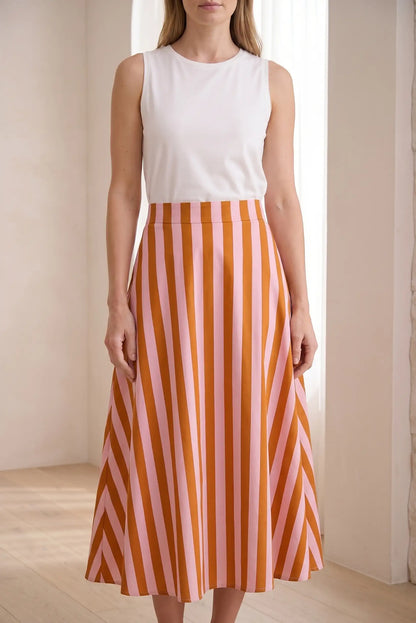 Falda larga de rayas rosas y naranjas, estilo casual de primavera, mujer de pie.