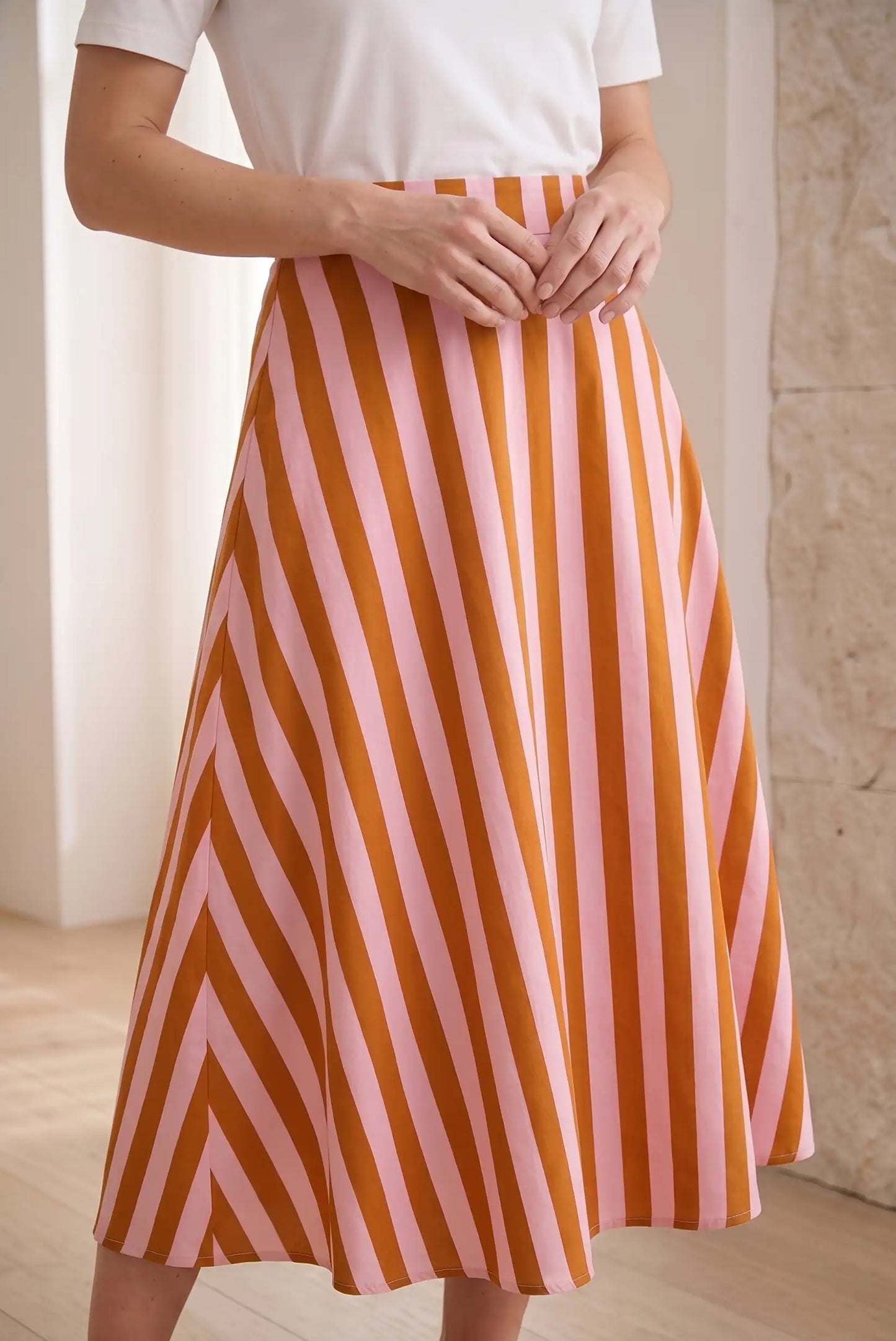Falda larga de mujer con rayas rosas y naranjas, look casual primaveral