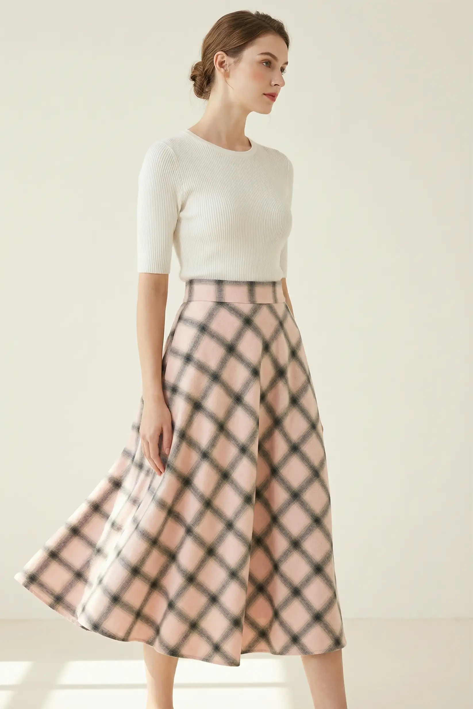 Mujer con falda larga rosa de cuadros, look casual CHICA del Sur, fondo neutro