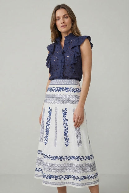 Falda blanca de mujer con bordados azul navy, look casual de primavera-verano