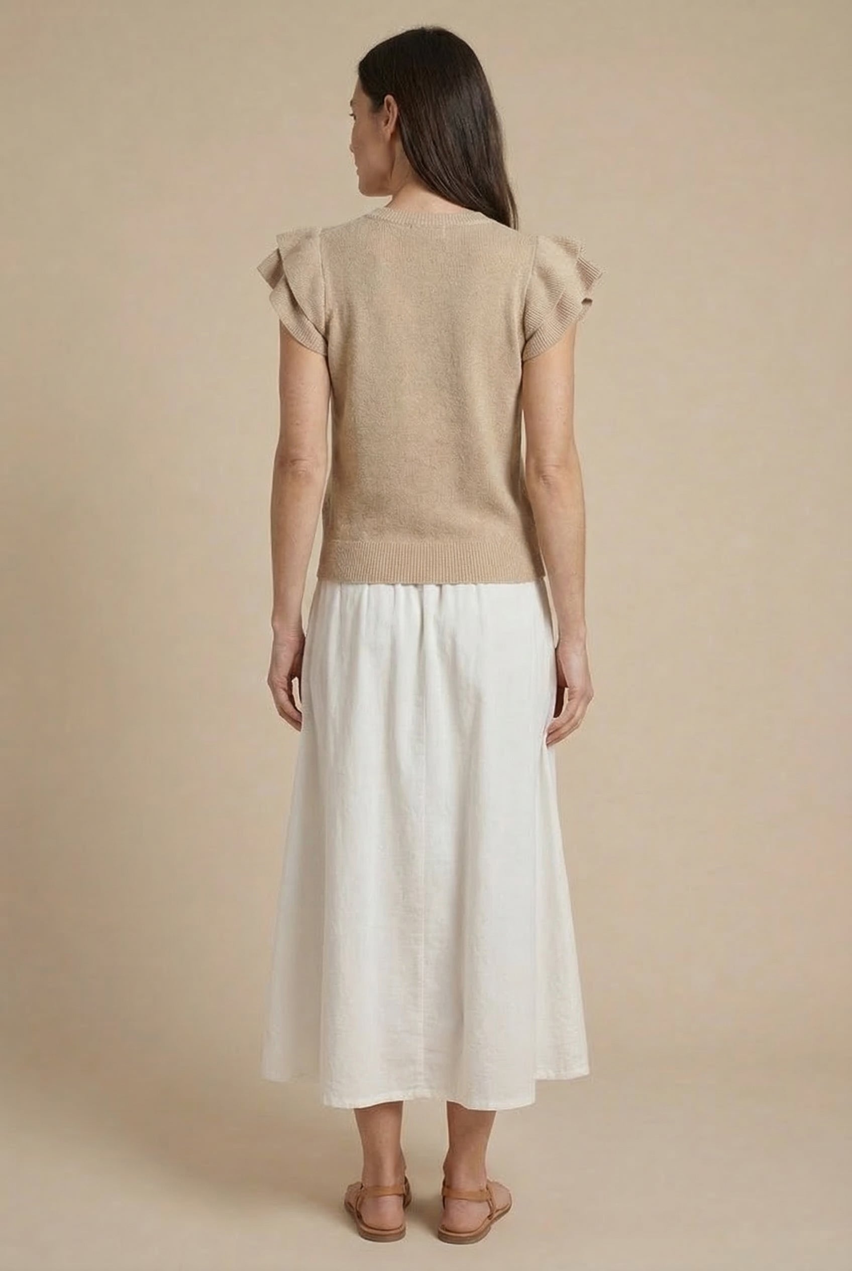 Falda larga blanca de mujer con bordado beige, estilo casual de primavera, vista trasera.