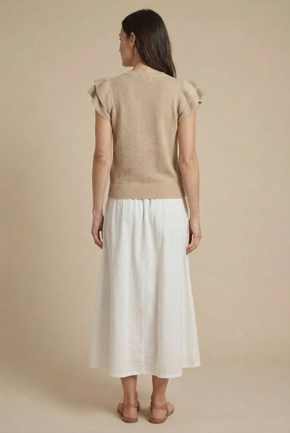 Falda larga blanca de mujer con bordado beige, estilo casual de primavera, vista trasera.