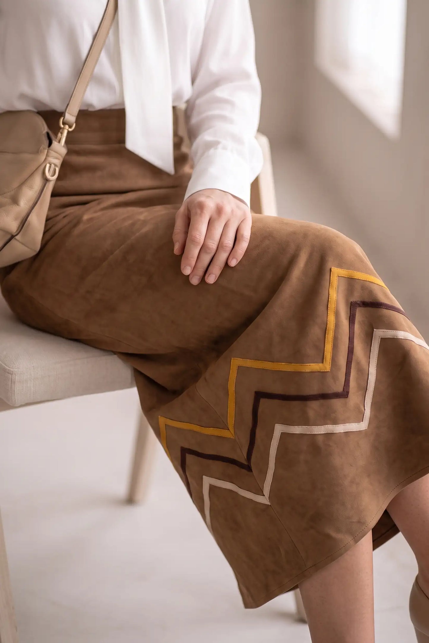 Falda midi marrón de ante con diseño de zig-zag en tonos ocre y marrón oscuro.