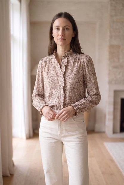 Blusa floral marrón con detalles de volantes y pantalones blancos, moda femenina elegante