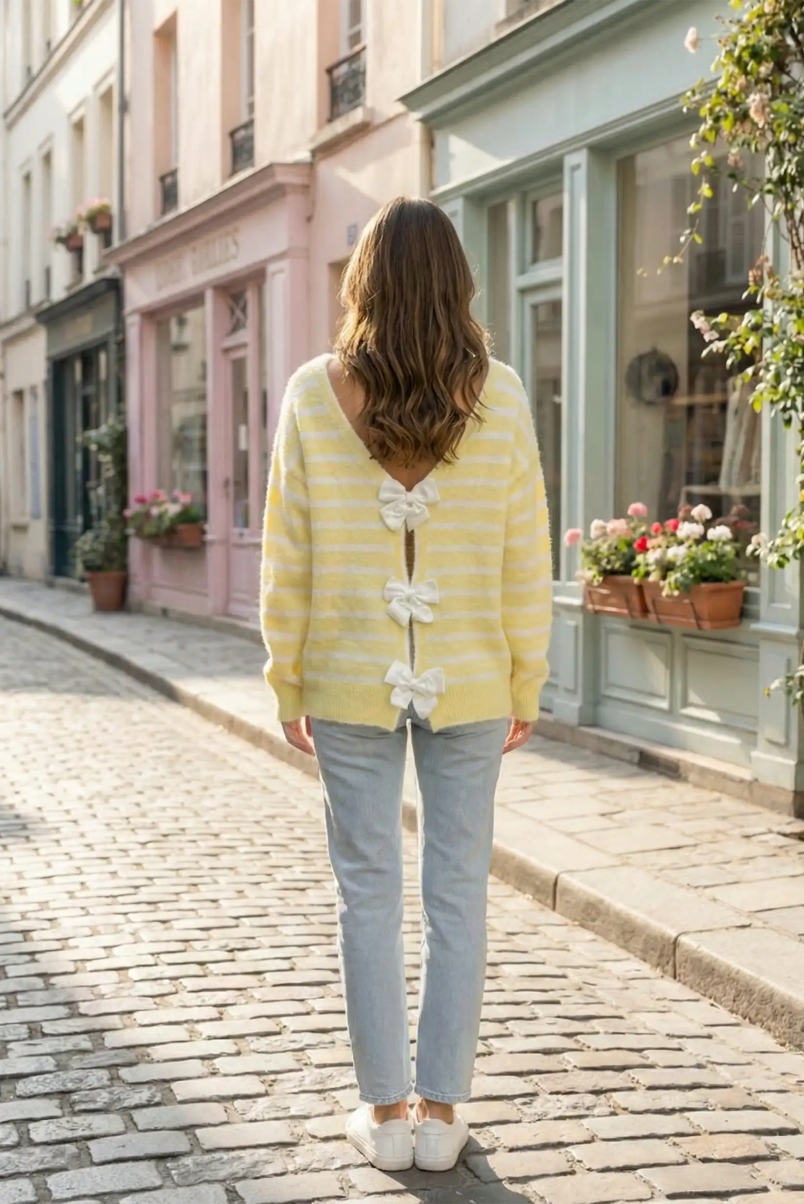 Mujer con jersey amarillo pastel de rayas y lazo trasero, moda CHICA del Sur en calle peatonal