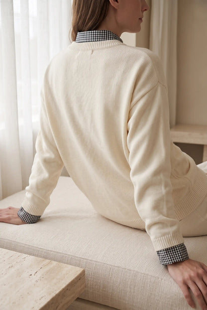 Vista trasera de mujer con jersey beige de CHICA del Sur y camisa de cuadros debajo