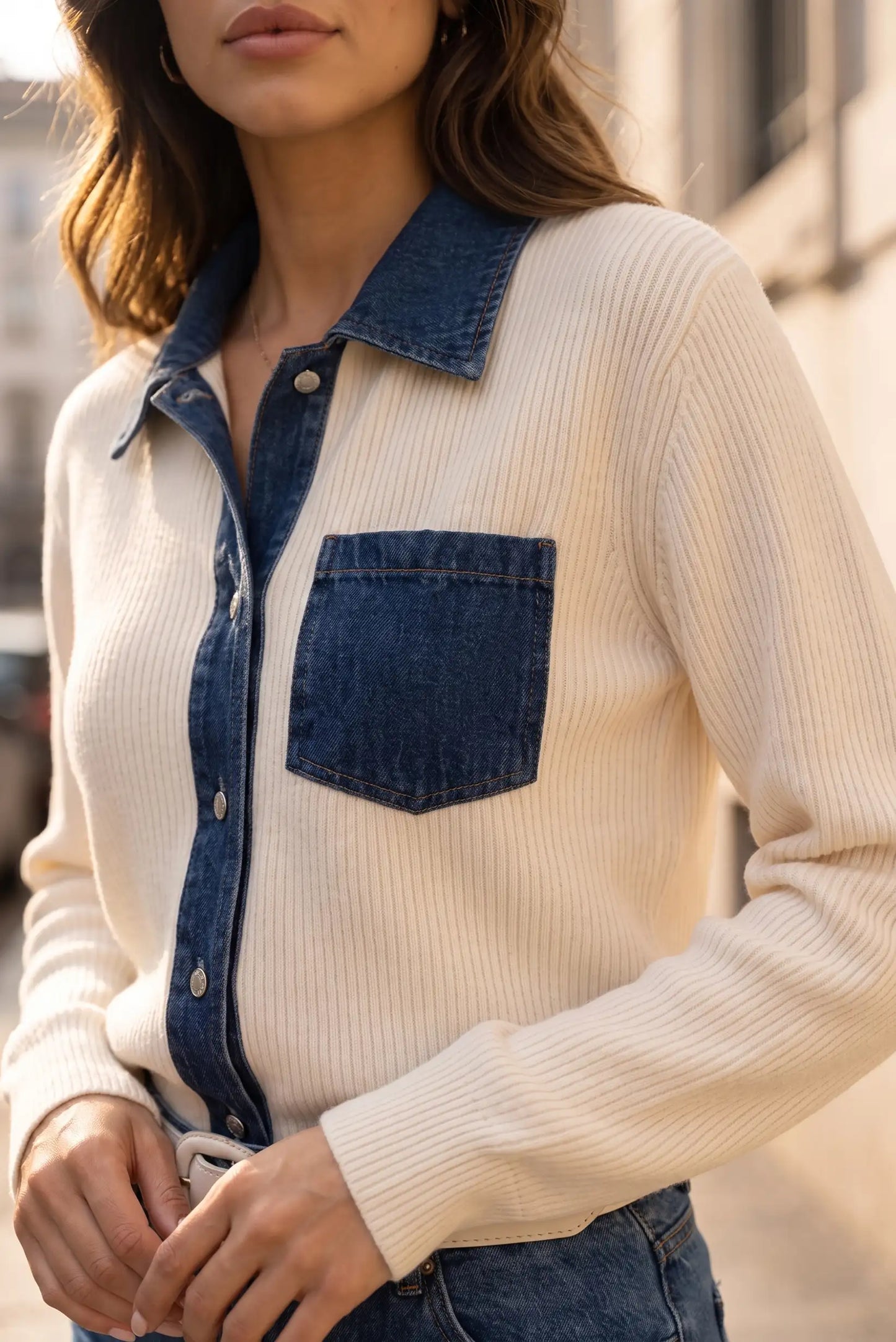 Mujer vistiendo jersey acanalado color crema con detalles de cuello y bolsillo en denim azul.