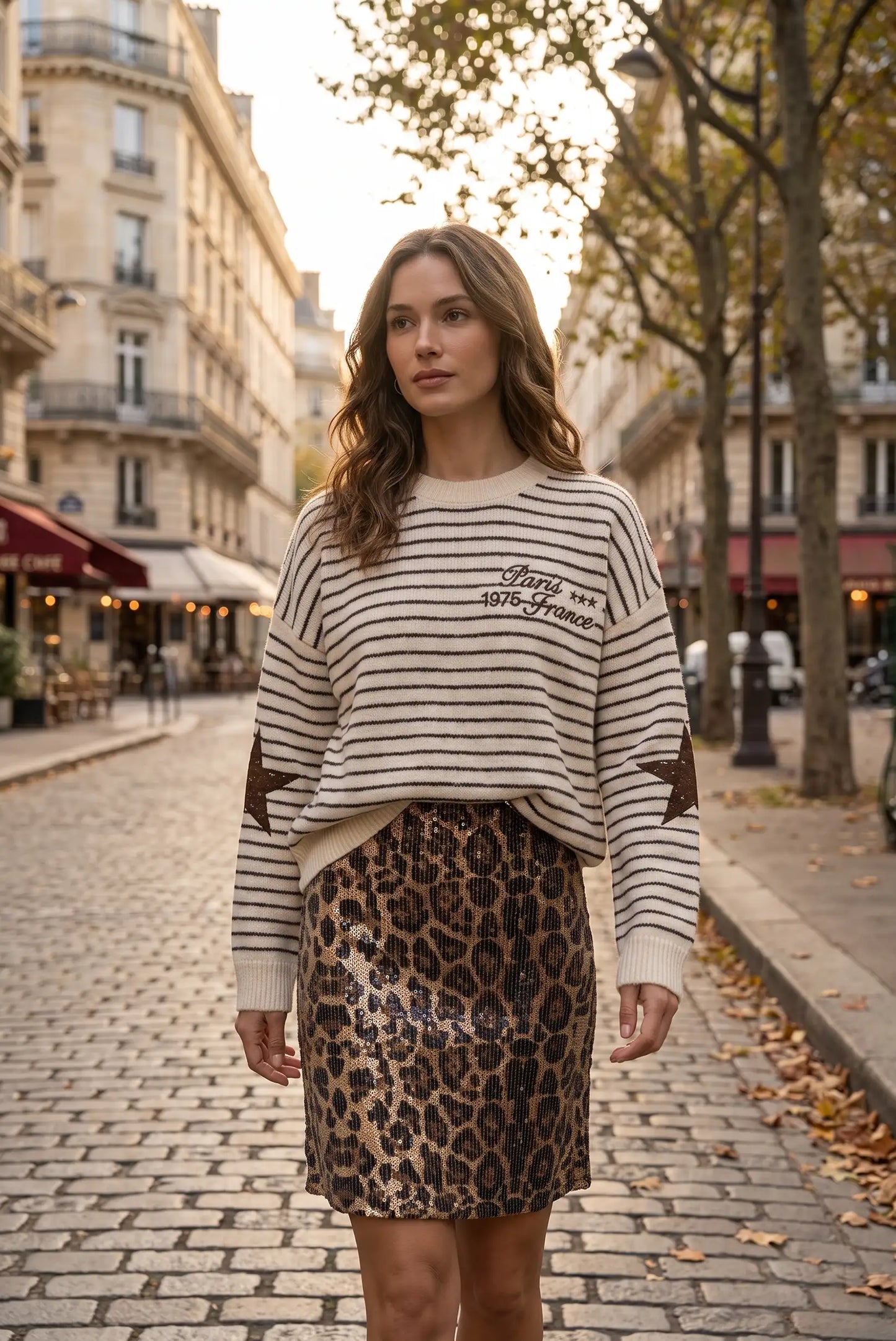 Mujer con jersey de rayas beige y falda corta de lentejuelas con estampado de leopardo.