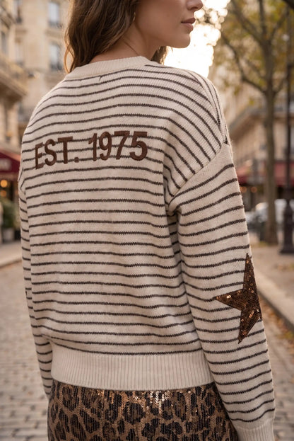 Jersey de rayas beige y marrón con texto 'EST. 1975' y estrella de lentejuelas en la manga