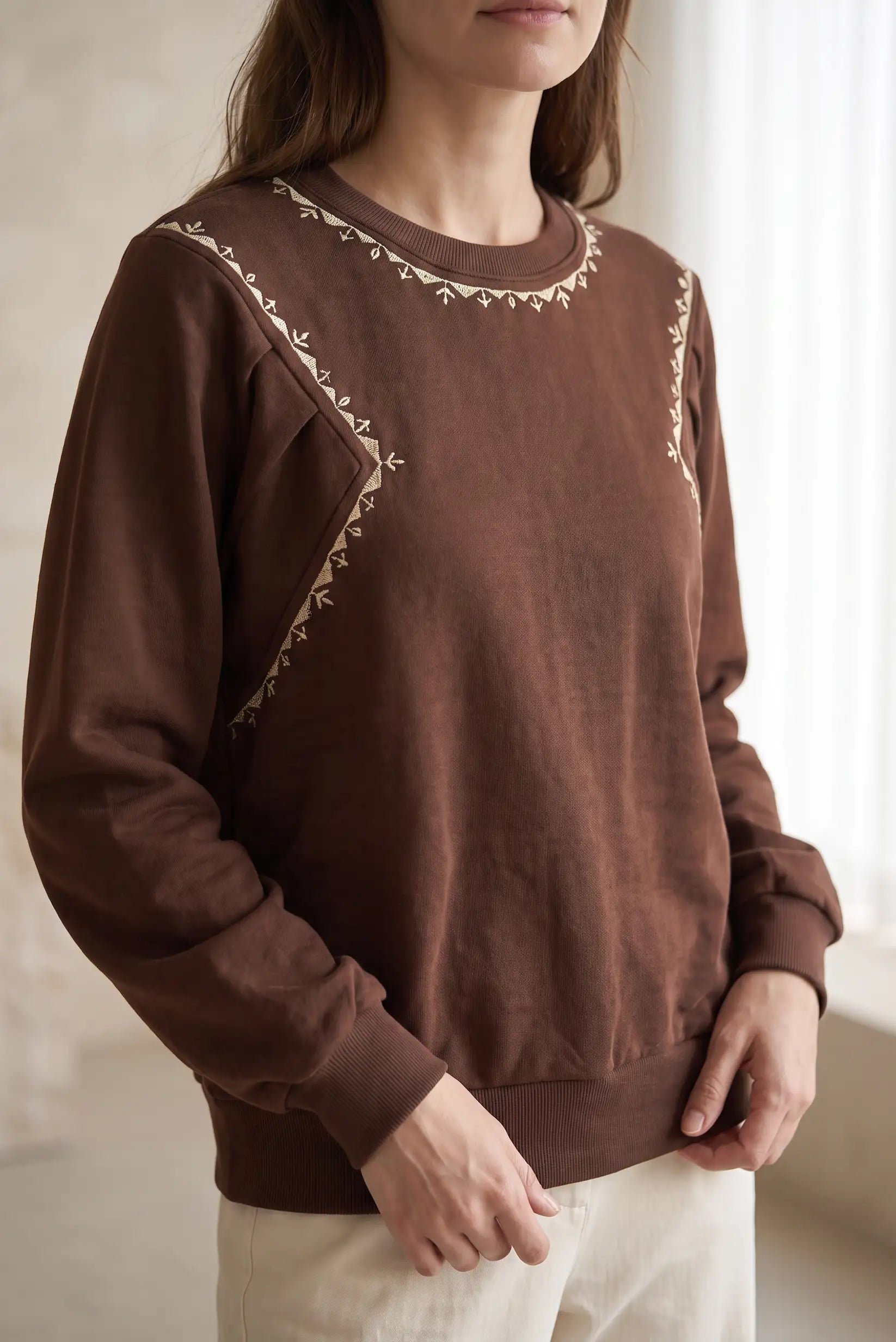 Sudadera marrón para mujer con bordados artesanales en color crema en el cuello y hombros.