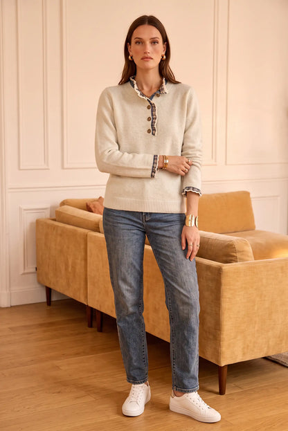 Suéter beige con detalles de encaje y jeans azules, ideal para looks casuales y elegantes