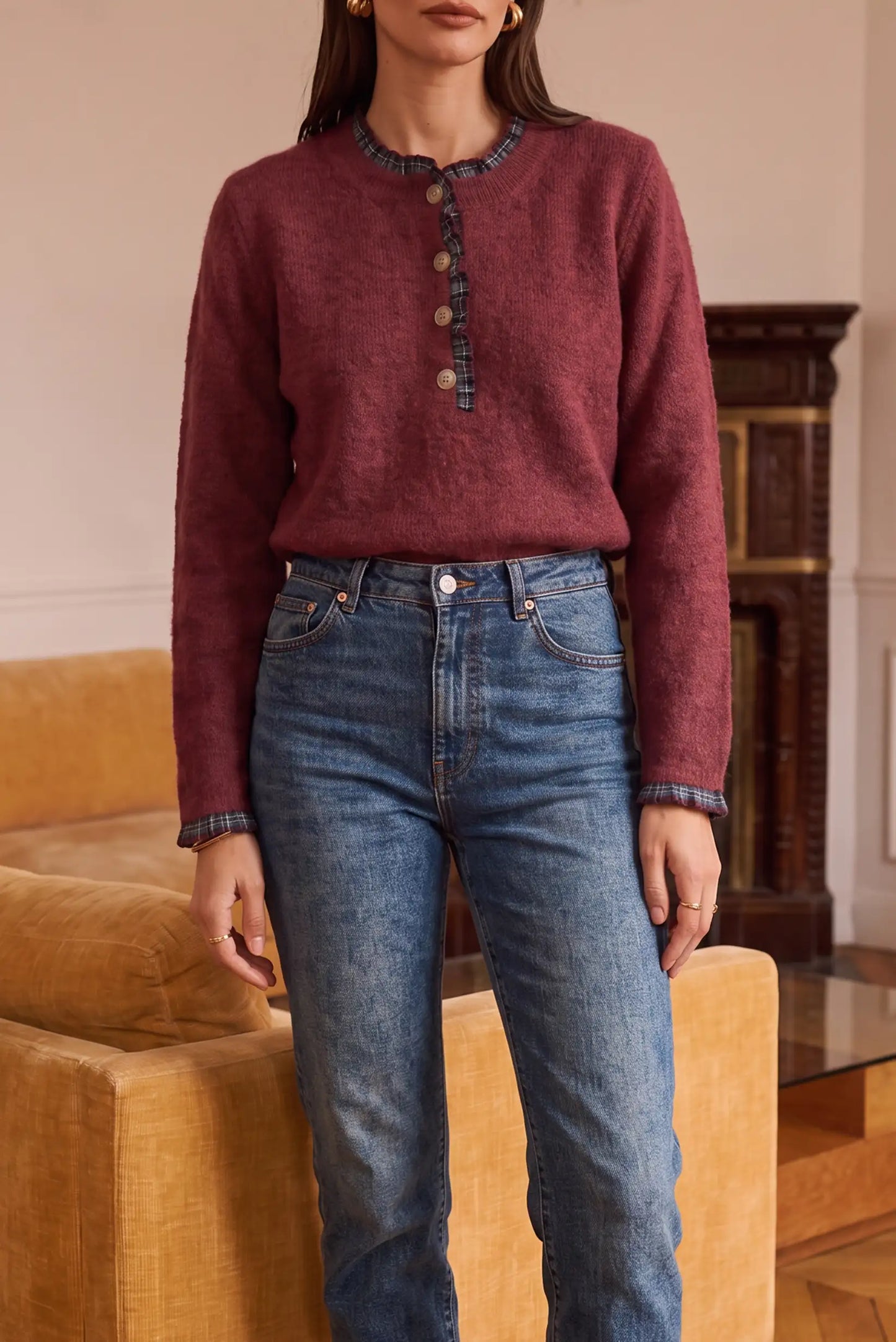 Jersey de punto burdeos con botones y detalles a cuadros, combinado con jeans azules de corte recto