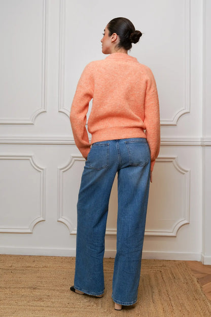 Mujer de espaldas con jersey naranja salmón y jeans anchos, moda casual CHICA del Sur