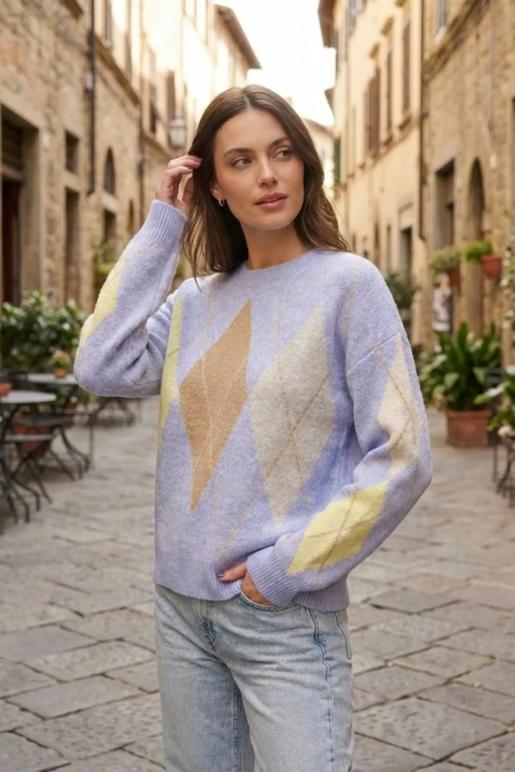 Mujer con jersey azul y beige de rombos, moda casual CHICA del Sur en calle empedrada.