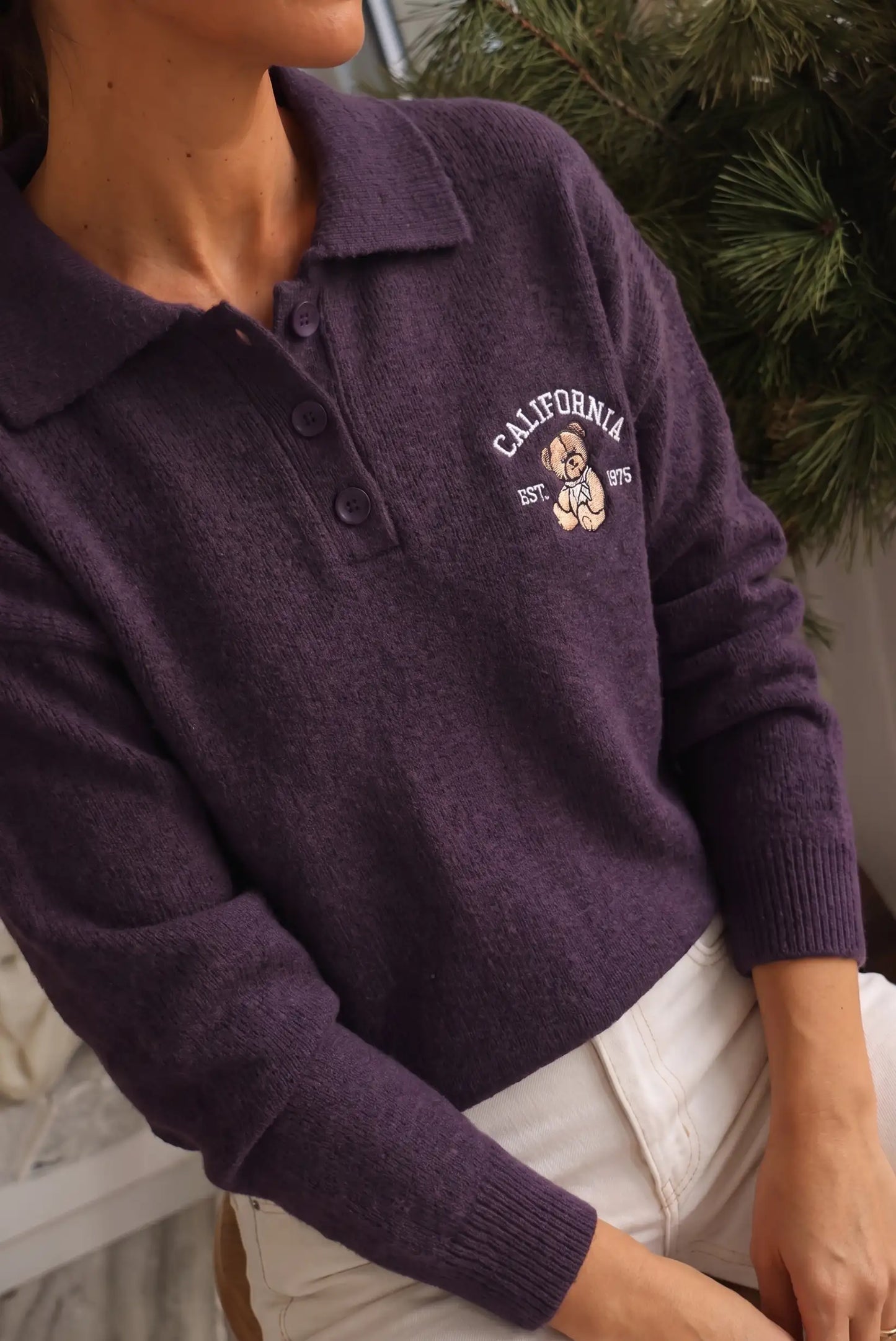 Jersey de punto morado con cuello polo y estampado de oso con el texto California.