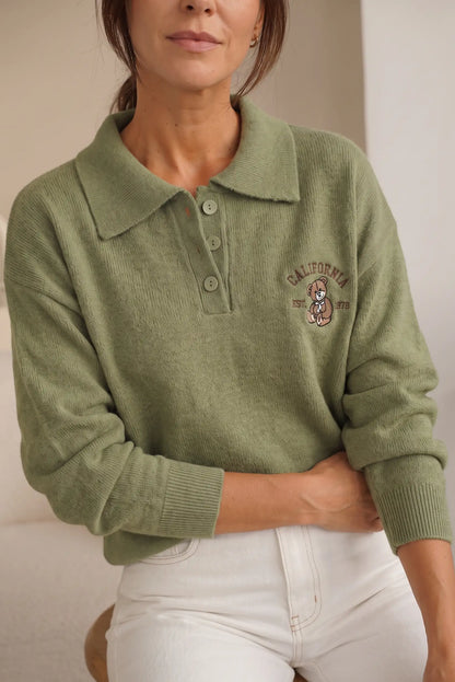 Mujer vistiendo un jersey de punto color verde oliva con cuello polo y bordado de California.