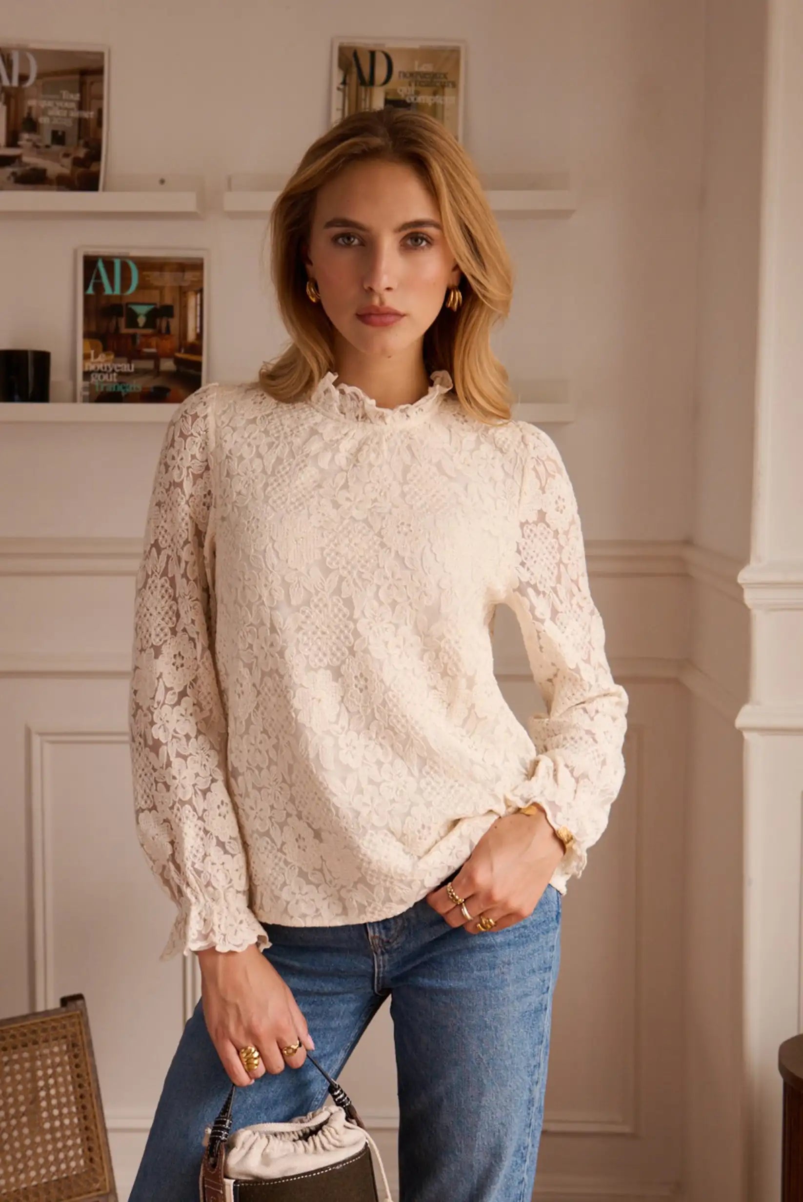 Blusa de encaje blanco con mangas largas y jeans azules, ideal para looks femeninos y elegantes