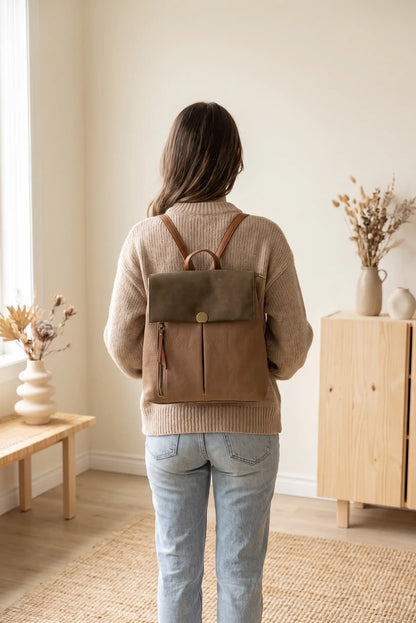Mujer de espaldas con jersey beige y mochila de cuero marrón y verde oliva
