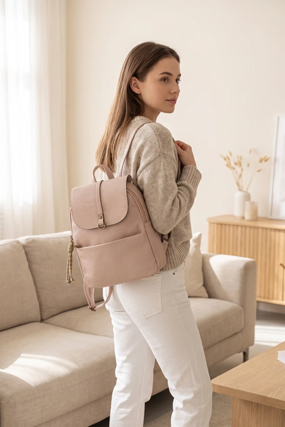 Mujer joven con jersey beige y pantalones blancos llevando una mochila rosa palo