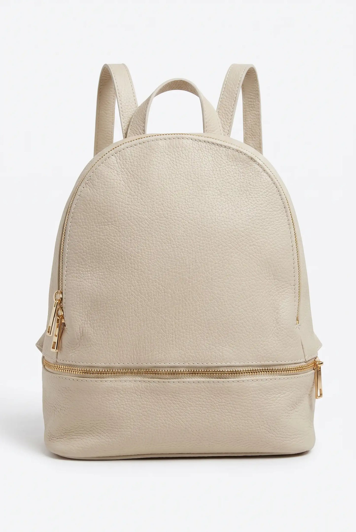 Mochila urbana de mujer en cuero beige con cremalleras doradas, estilo casual moderno.